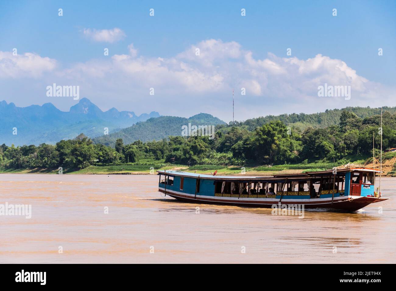 Traditionelles Touristenboot, das auf dem schlammigen Mekong-Fluss segelt. Luang Prabang, Laos, Südostasien Stockfoto