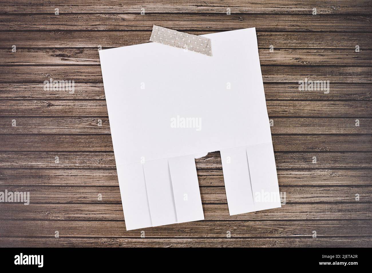 Weiße leere Abrissnotiz aus Stichpapier ohne Text an der Holzwand Stockfoto