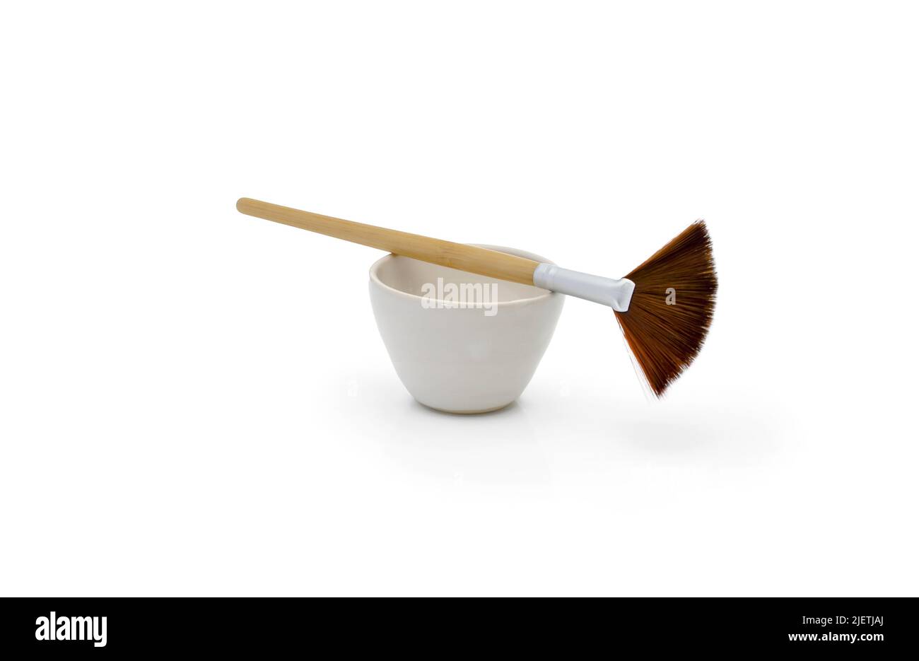 Pinsel und Schüssel auf weißem Hintergrund Stockfoto