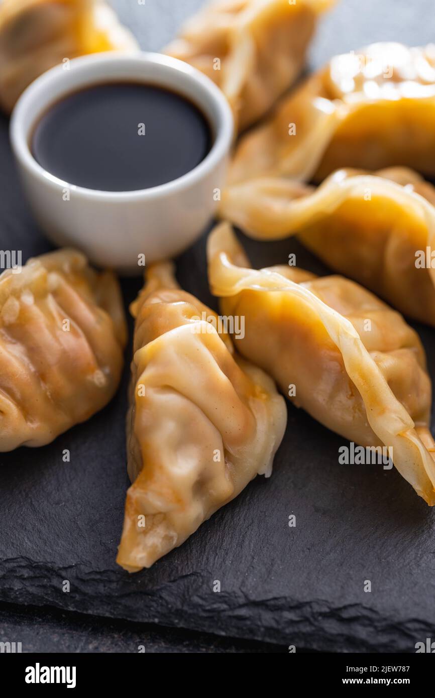 Chinesische Knödel und sojasauce auf einem Schneidebrett. Stockfoto
