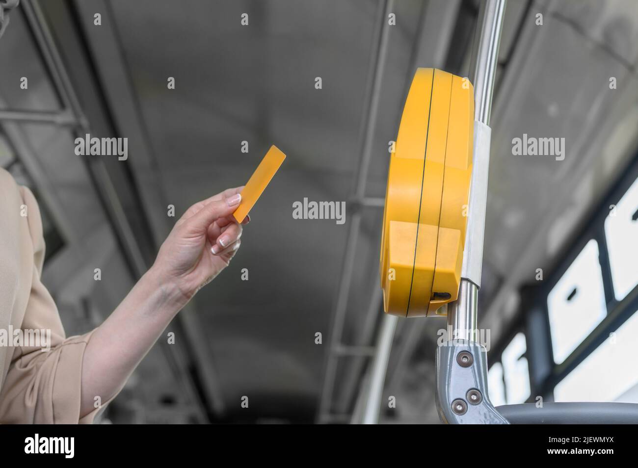 Eine Frau zahlt mit einer Plastikkarte für die Fahrt im öffentlichen Verkehr in einem Bus, Straßenbahn oder U-Bahn Stockfoto