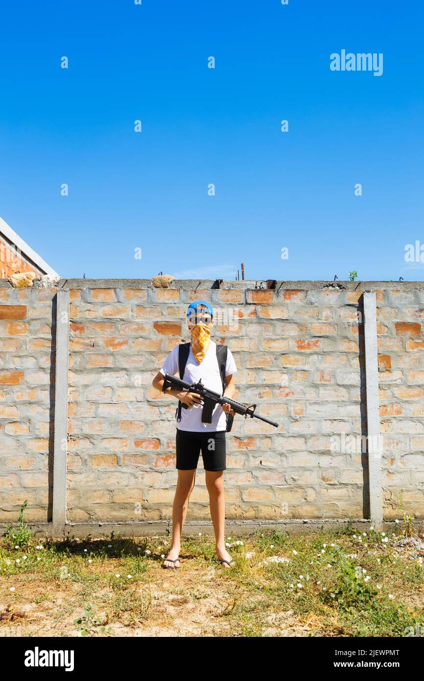 Kinderschütze steht mit einem automatischen Gewehr. Schusskonzept. Stockfoto
