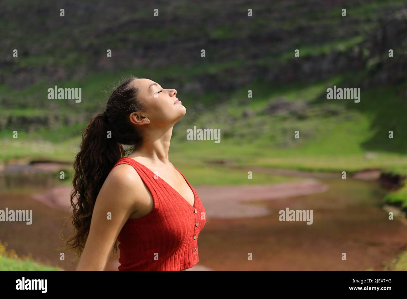 Profil einer lässigen Frau, die in einem Flussufer im Berg frische Luft atmet Stockfoto