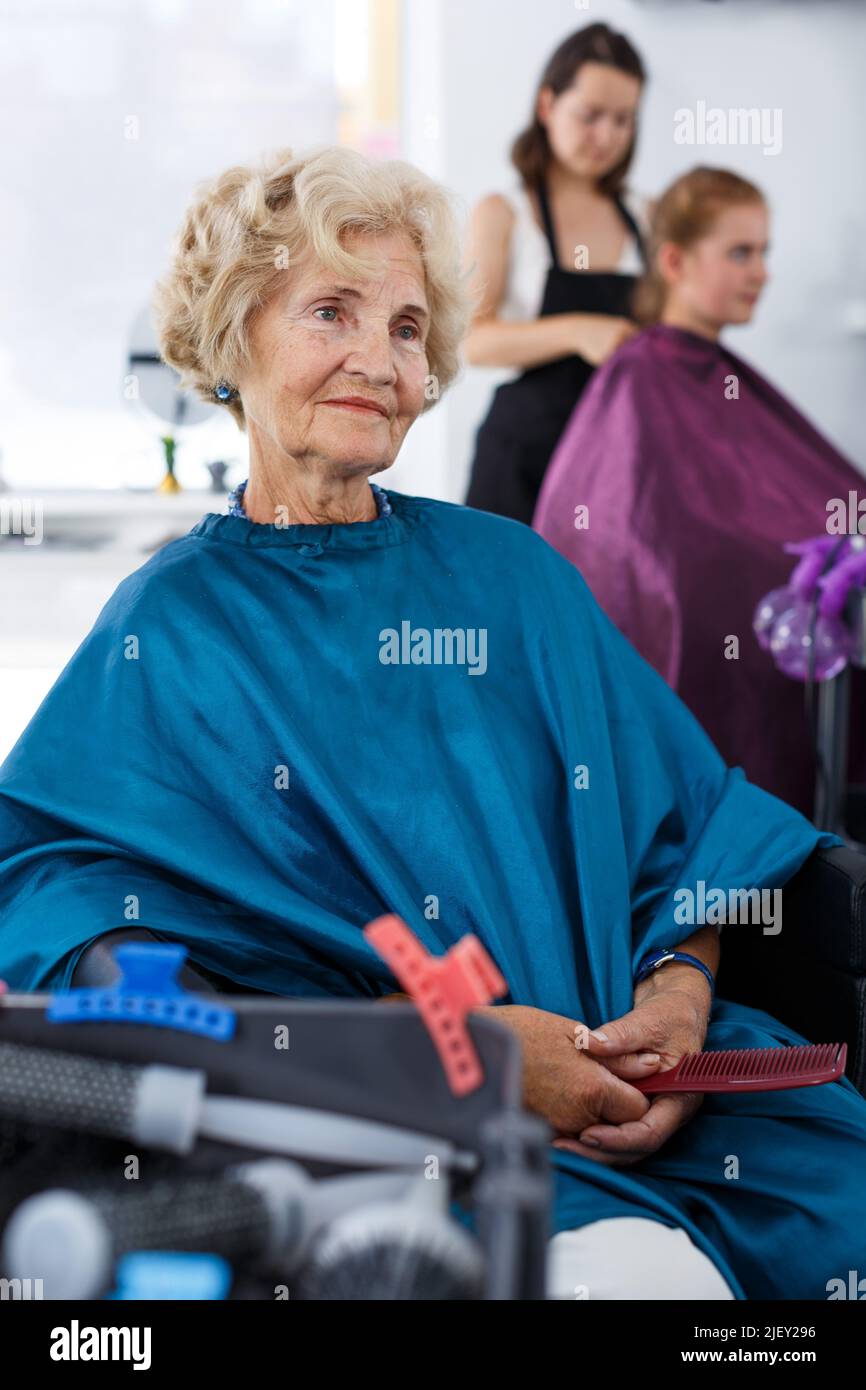 Ältere weibliche Klientin wartet auf das Styling der Haare Stockfoto