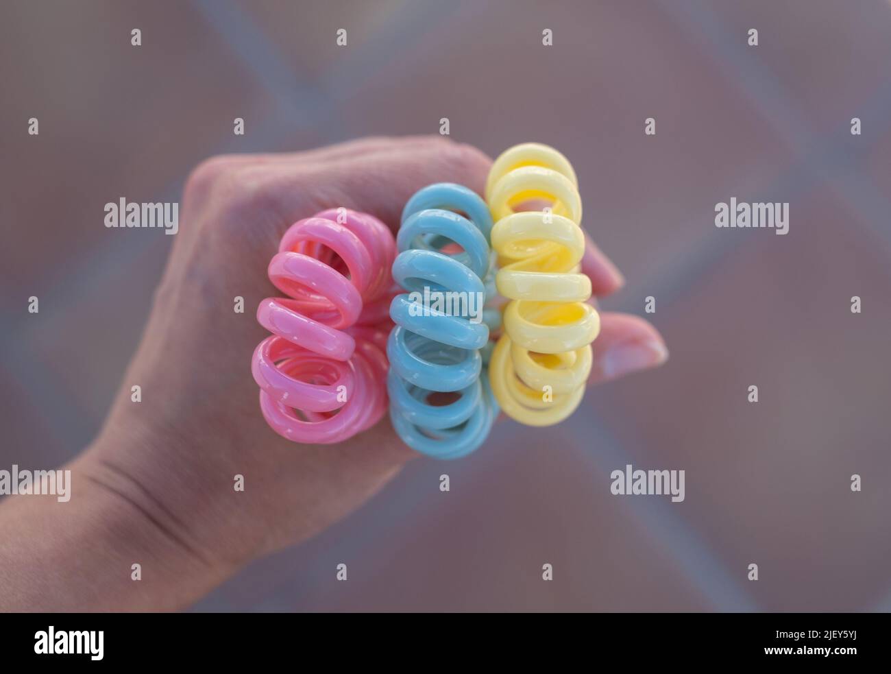 Plastikspirale schrunchies Haarband in der Hand. Farbige spiralförmige Haarbänder Stockfoto
