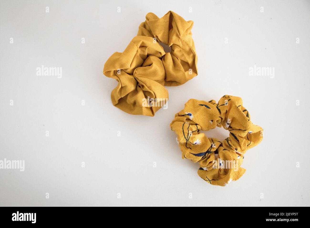 Flach lagen zwei gelbe Haarrunchies Stockfoto