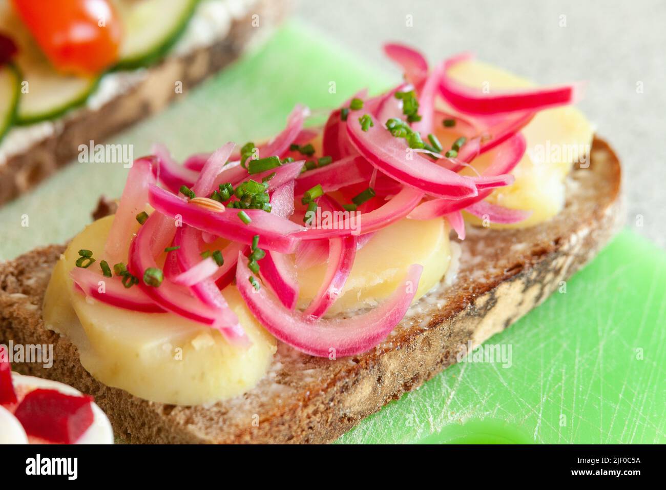 Dänisches Sandwich mit eingelegten roten Zwiebeln und offenen Kartoffeln Stockfoto