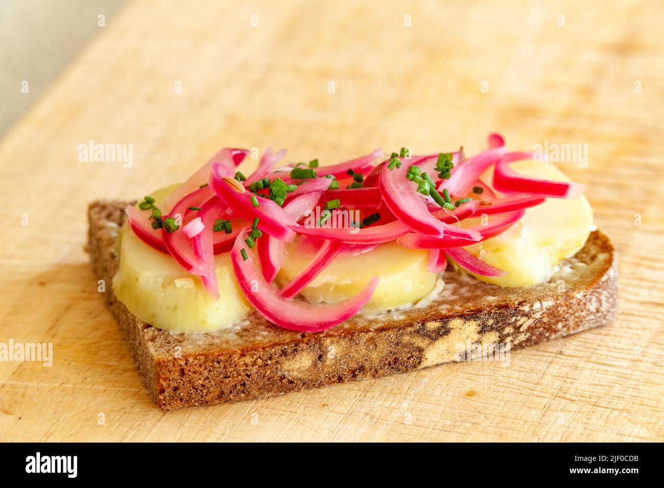 Dänisches Sandwich mit eingelegten roten Zwiebeln und offenen Kartoffeln Stockfoto