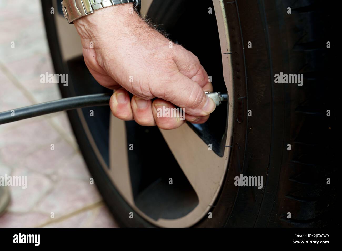 Nahaufnahme eines Mechanikers, der einen Autoreifen aufbläst Stockfoto