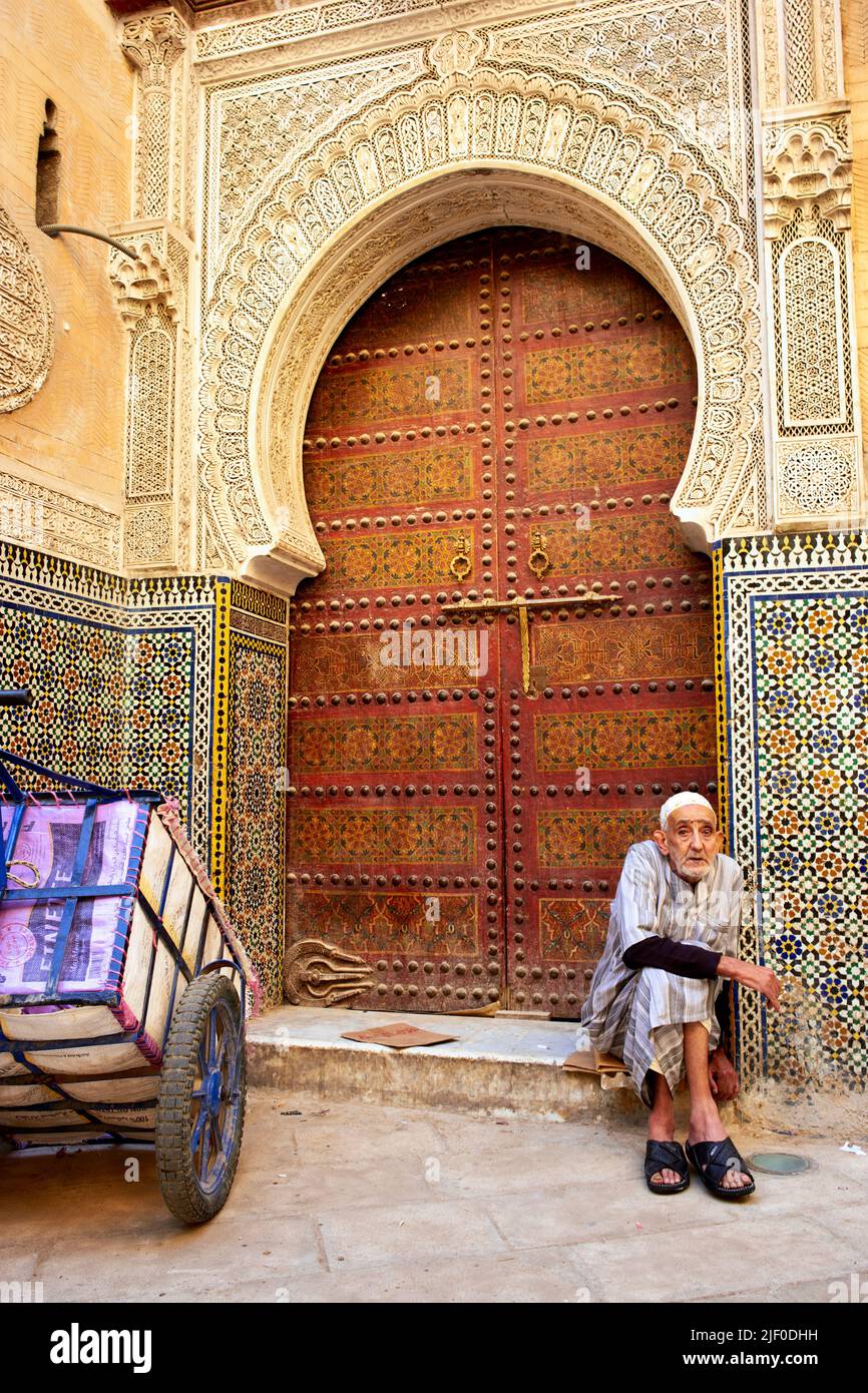 Marokko Fez. Ein reifer Mann saß an der Tür eines historischen Gebäudes in der Medina Stockfoto