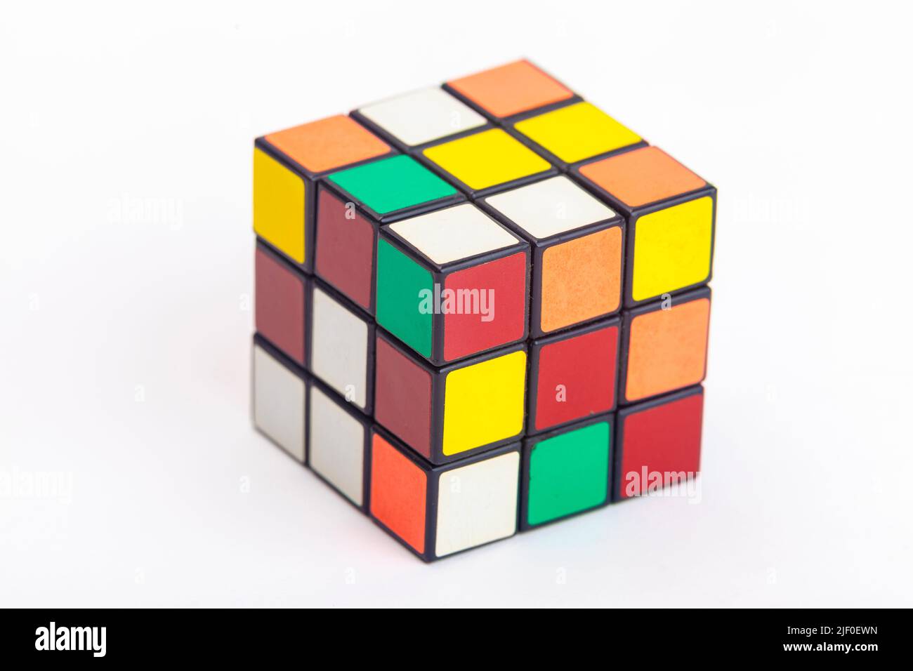 Ein ungelöster rubiks-Würfel auf weißem Hintergrund. Stockfoto