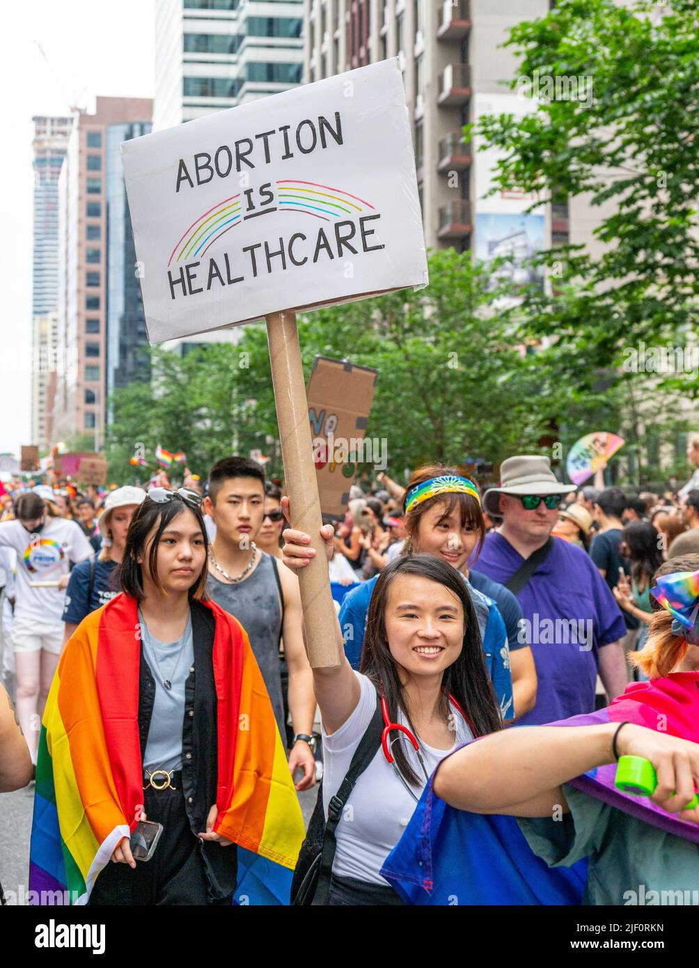 Eine Frau asiatischer Abstammung hält ein Schild mit der Aufschrift „Abtreibung ist Gesundheit“, während sie während der Pride Parade marschiert. Stockfoto