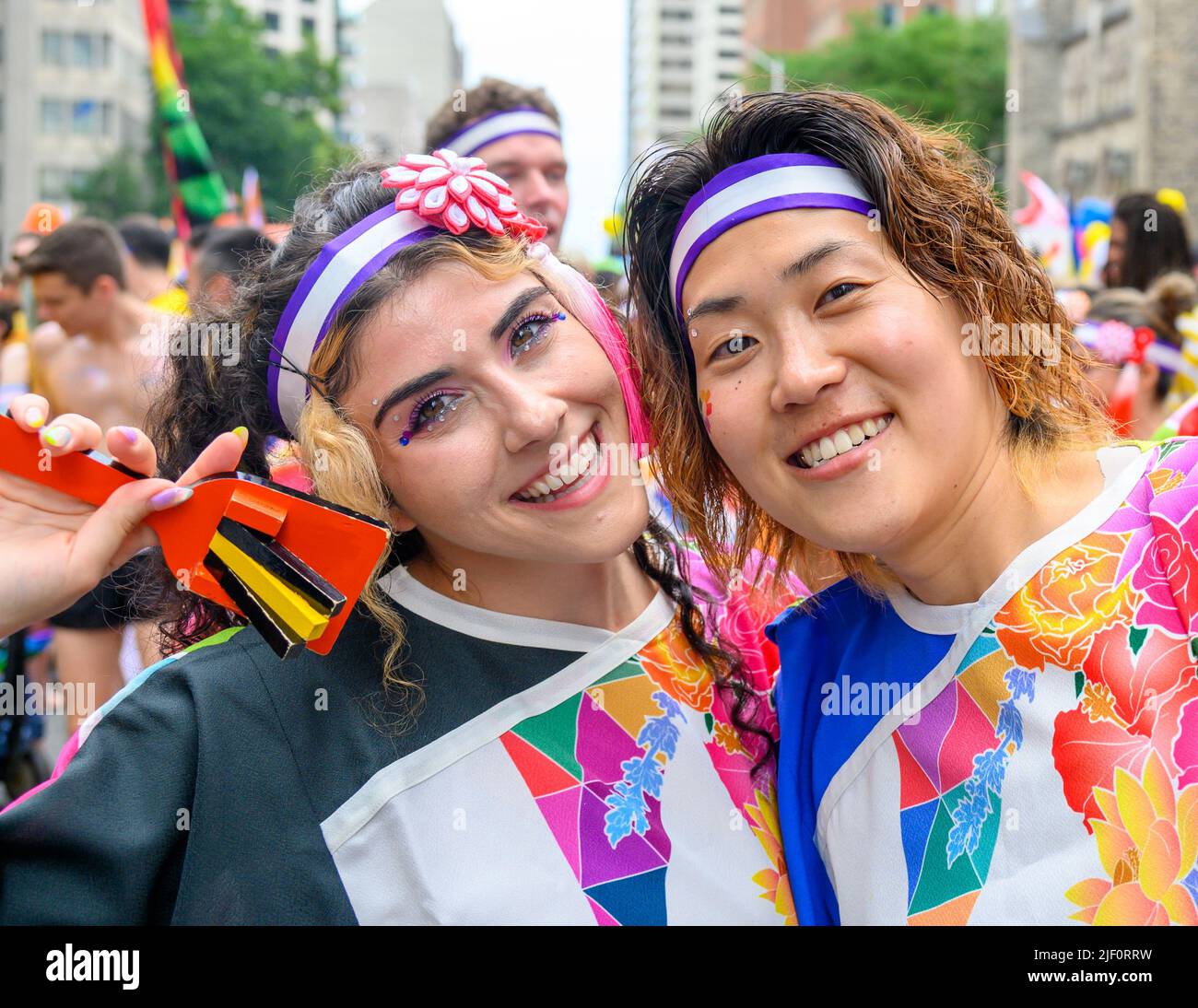 Porträt von zwei schönen Menschen lächeln. Sie sind Teil der Marschierenden in der Pride Parade. Stockfoto