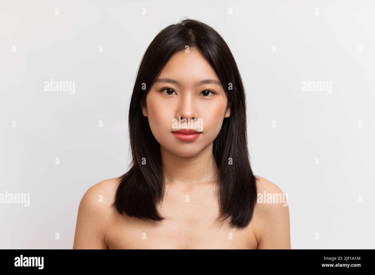 Beauty Face. Porträt der japanischen Dame mit natürlichen Make-up und gesunde Haut Blick auf die Kamera über weißem Hintergrund Stockfoto