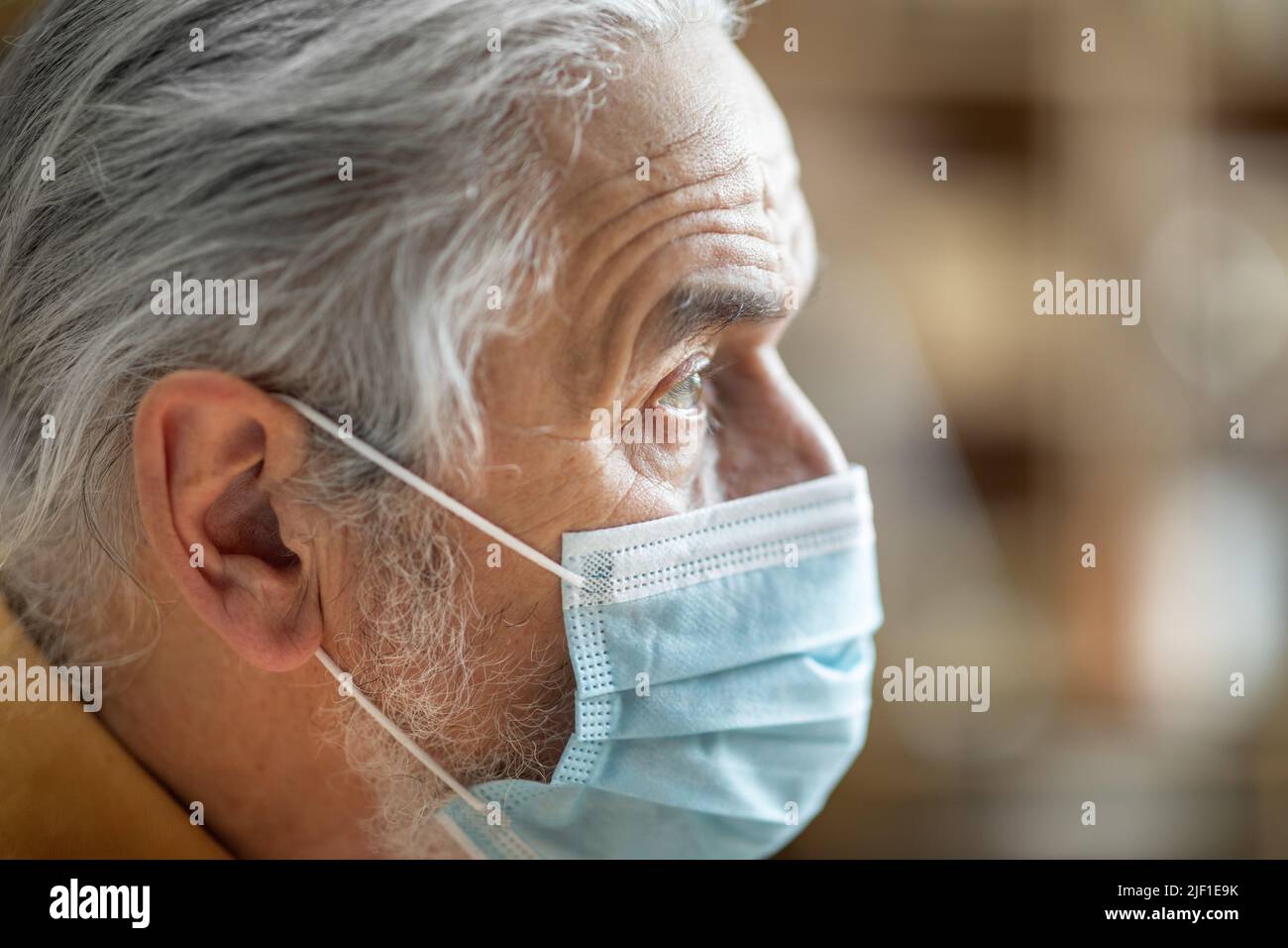 Nahaufnahme eines älteren Mannes, der eine schützende Gesichtsmaske trägt Stockfoto