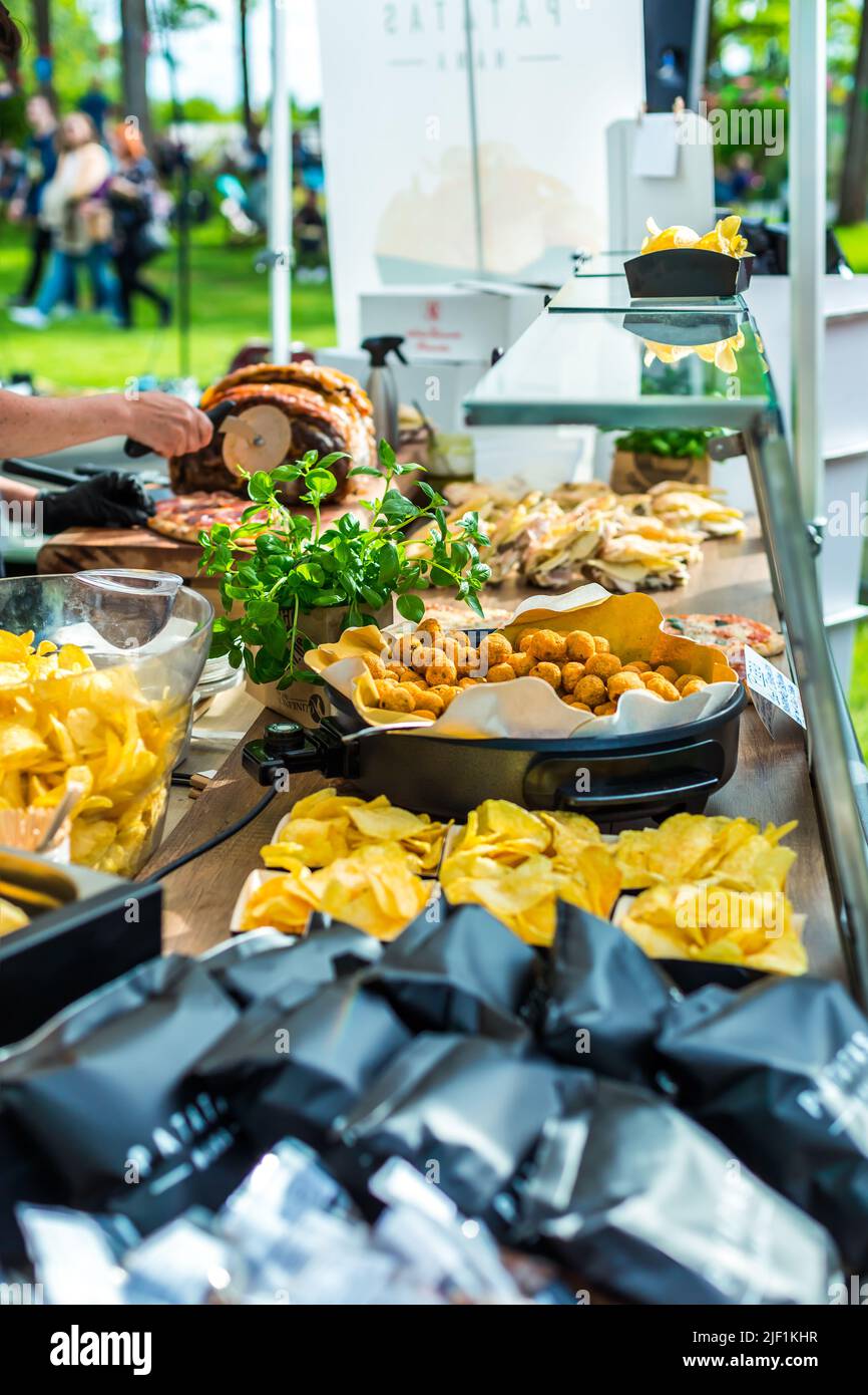 Variation von Fingerfood am Foodtruck. Street Food mit Kartoffelchips, Backed-Gemüsebällchen und Fleisch-Sandwiches Stockfoto