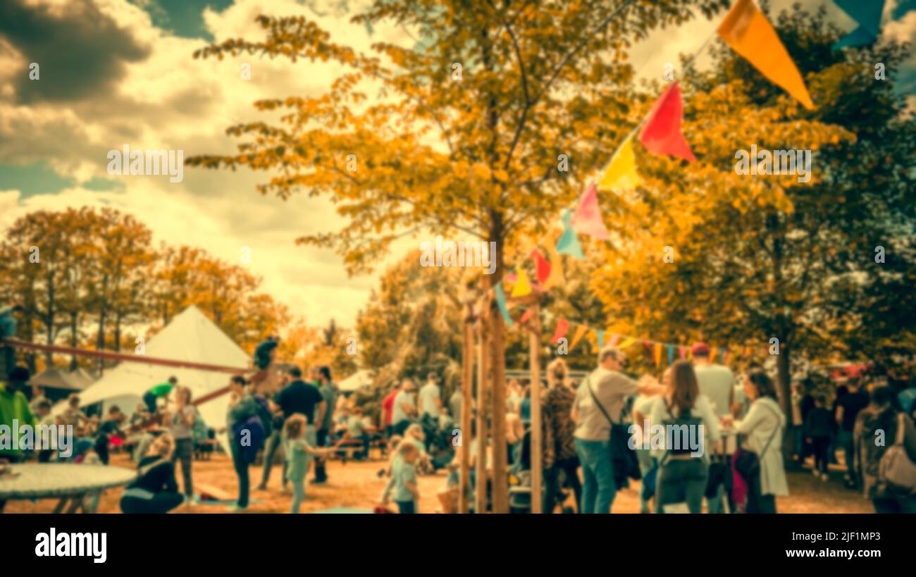 Abstraktes, unscharfes Bild von Menschen und Food Trucks im Vintage-Stil. Verwischen Sie das Bild des Straßenfestivals mit Bokeh für den Hintergrund Stockfoto