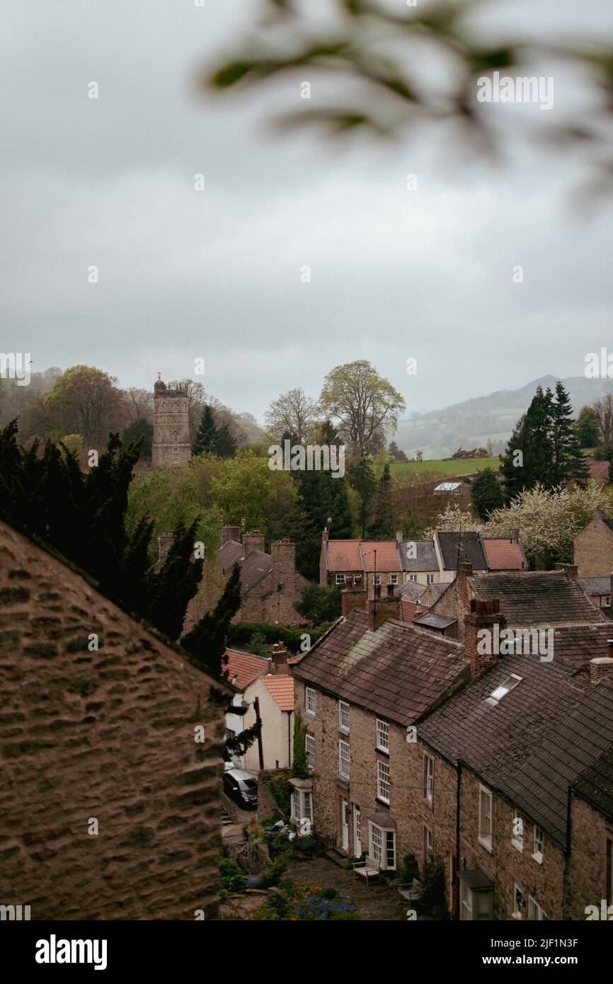 Überfüllte historische Stadt Richmond, Yorkshire, Großbritannien, mit einer alten Kirche, die strategisch auf einem Hügel thront. Stockfoto