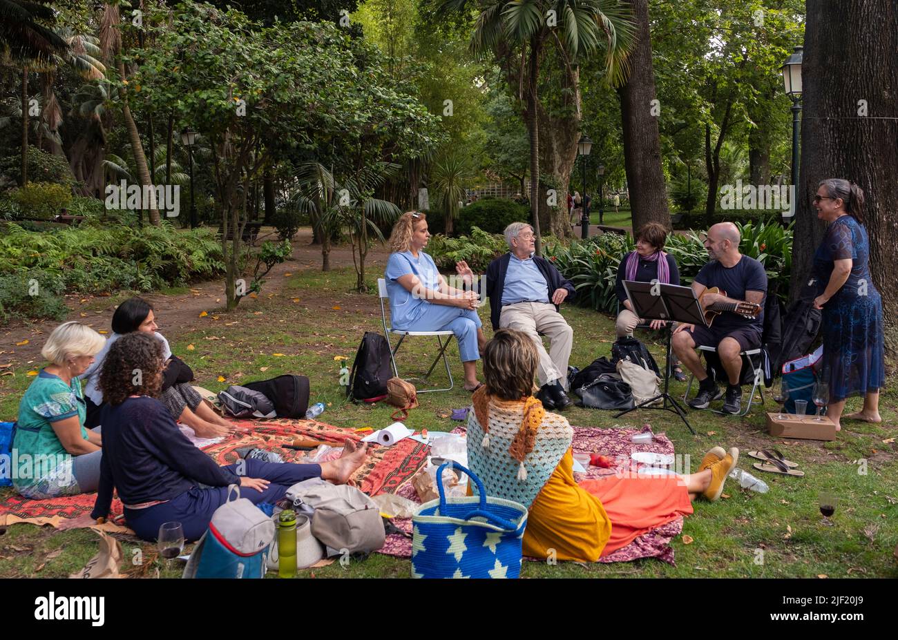 Eine Gruppe von Leuten, die in einem Lissabonner Park ein Picknick machen und Musik spielen Stockfoto