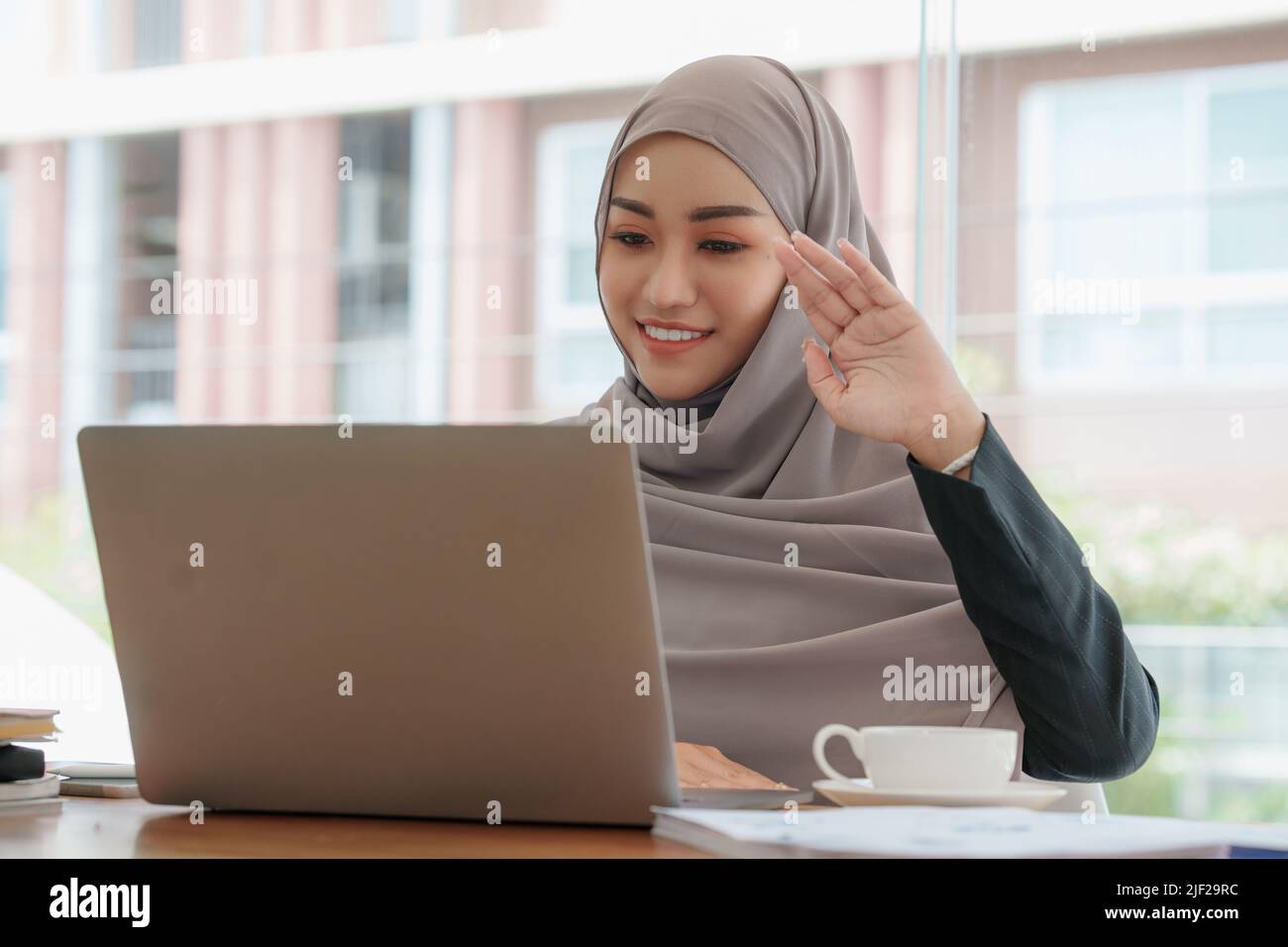 Portrait von glücklichen asiatischen schönen Mädchen machen Video-Anrufe mit Laptop und winken auf dem Handy-Bildschirm zu Hause. Vorstellungsgespräch Remote-Konzept. Stockfoto