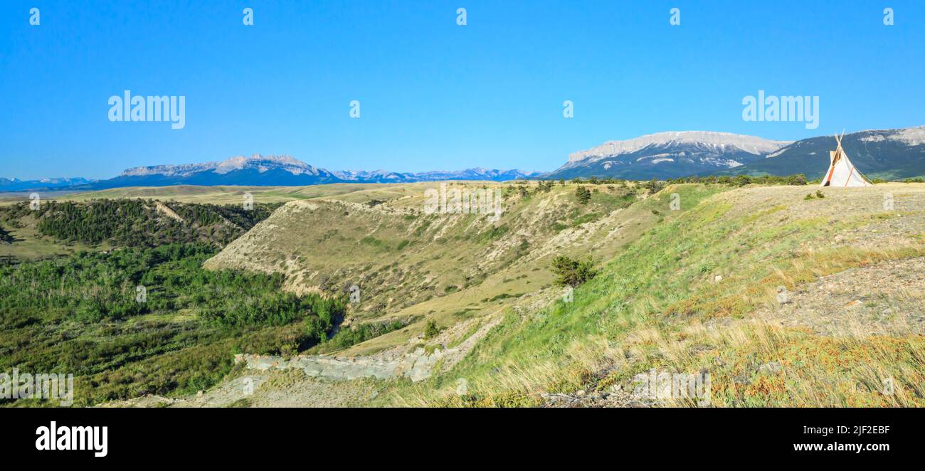 Panorama eines eineinigen Tipi über tiefem Bachtal entlang der felsigen Bergfront in der Nähe von Choteau, montana Stockfoto