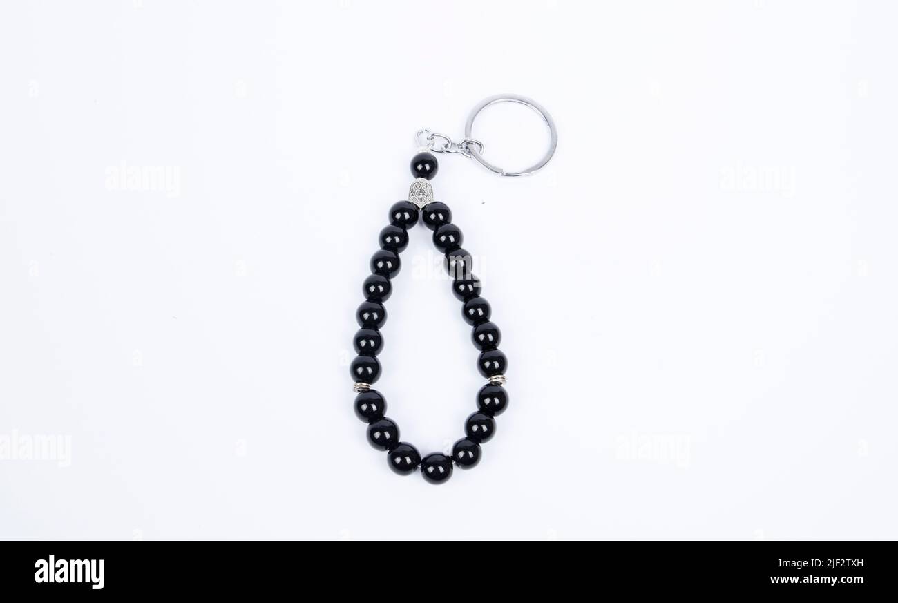 Gebetsperlen mit 33 Knoten aus Stein auf matter Oberfläche auf weißem Grund Stockfoto