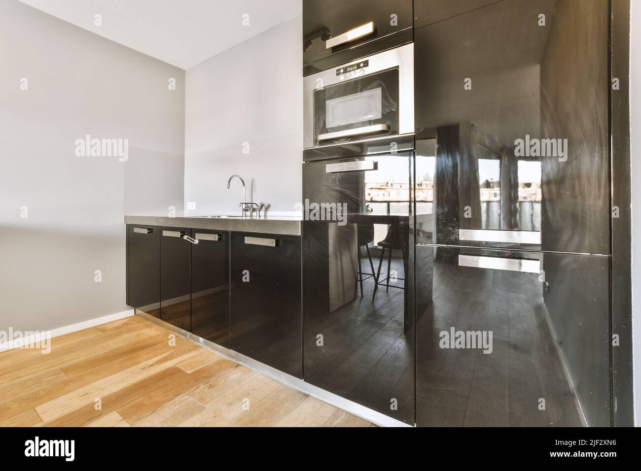 Home Interior Design der modernen Loft-Wohnung mit offener Küche In minimalistischem Stil und geräumiger Essecke mit Tisch und Stühle Stockfoto