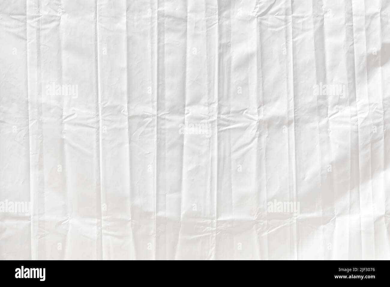 Gefaltetes und faltiges weißes Kunststoff-Polytarp-Planenmaterial als abstrakter Hintergrund und Textur Stockfoto