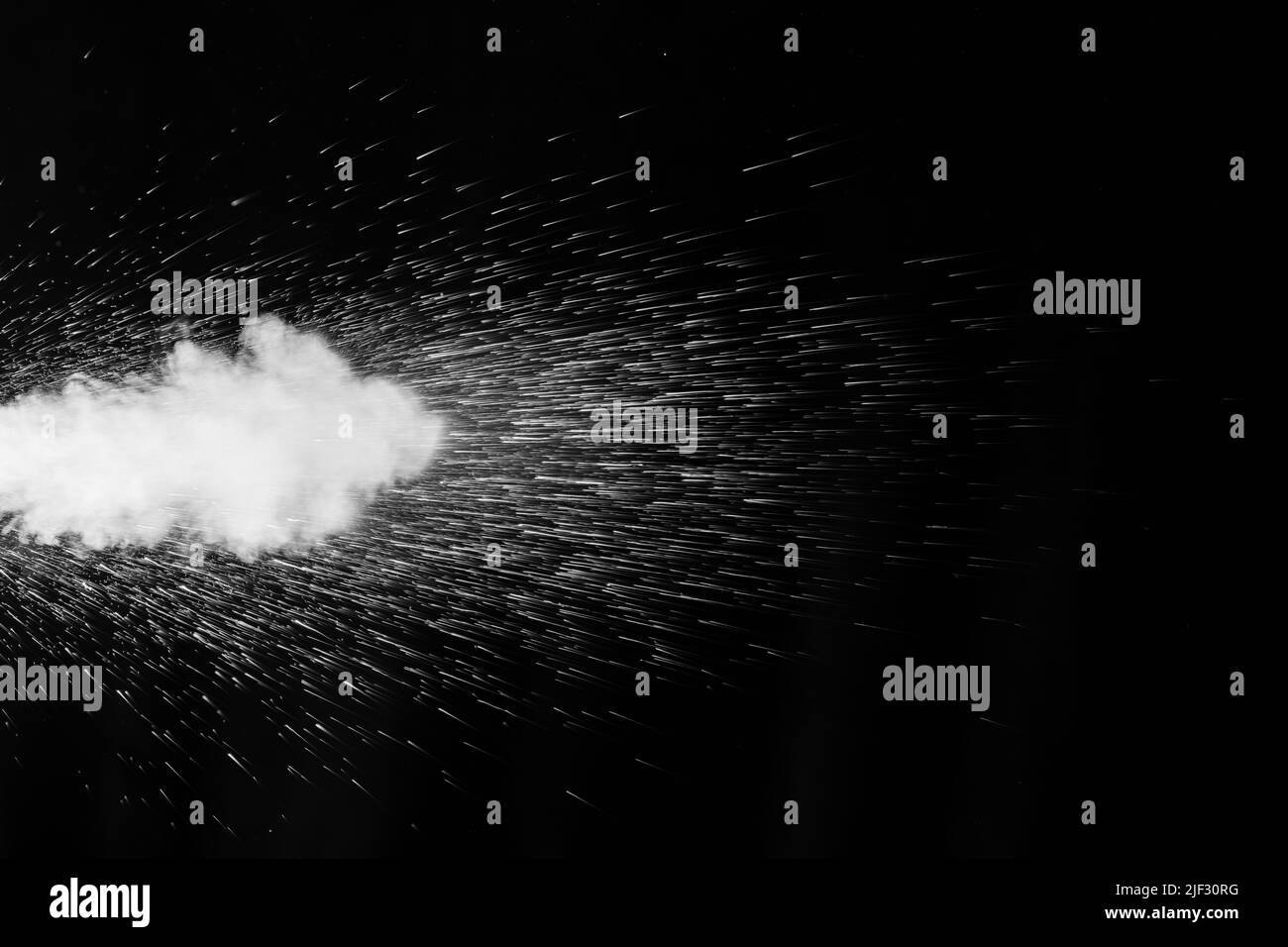 Horizontaler Dampf mit Sprühtropfen, die in verschiedene Richtungen auf einem schwarzen Hintergrund fliegen, um ein Foto zu überlagern. Stream, Strahl von heißem Wasser mit Dampf Stockfoto