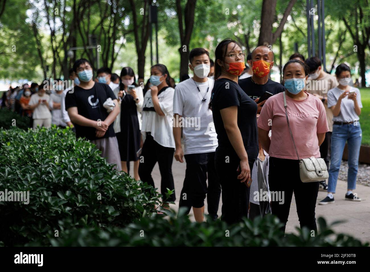 Nach einem Ausbruch der Coronavirus-Krankheit (COVID-19) stehen Menschen in Peking, China, am 29. Juni 2022, an einer Nukleinsäureteststation an. REUTERS/Thomas Peter Stockfoto