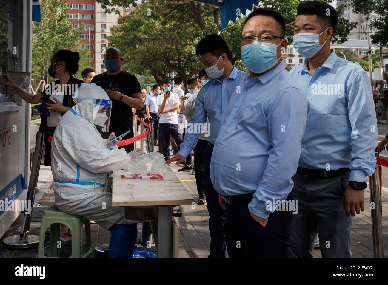 Nach einem Ausbruch der Coronavirus-Krankheit (COVID-19) stehen Menschen in Peking, China, am 29. Juni 2022, an einer Nukleinsäureteststation an. REUTERS/Thomas Peter Stockfoto