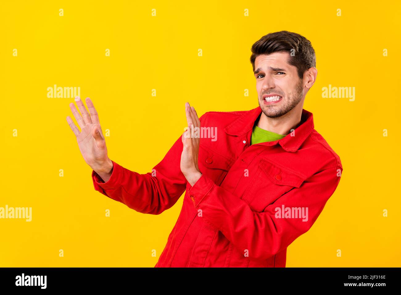 Portrait von attraktiven verärgerten Kerl zeigt Stop keine Abfälle isoliert über helle gelbe Farbe Hintergrund Stockfoto