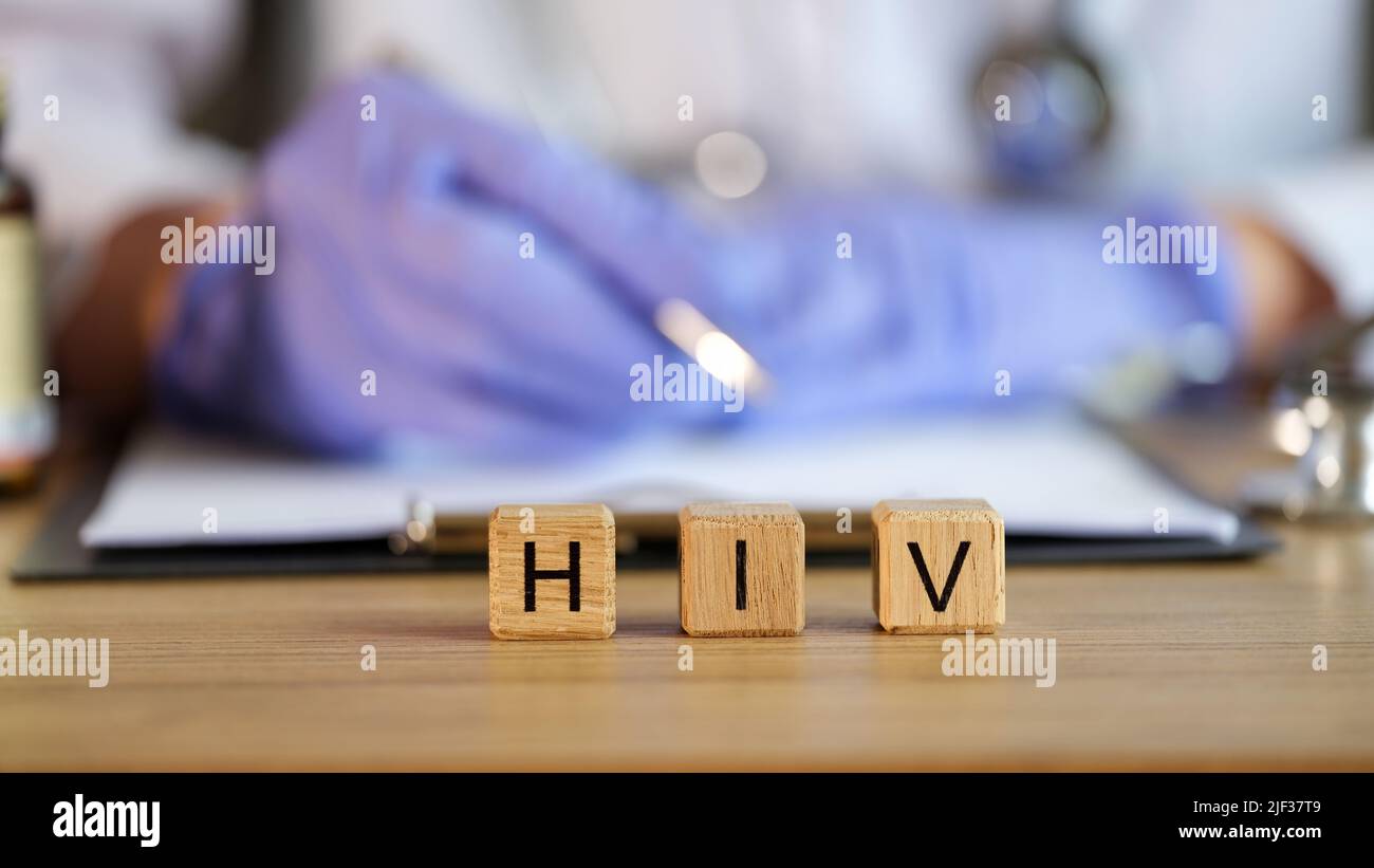 HIV-Text auf Würfeln in der medizinischen Klinik vor dem Hintergrund des Arztes Stockfoto
