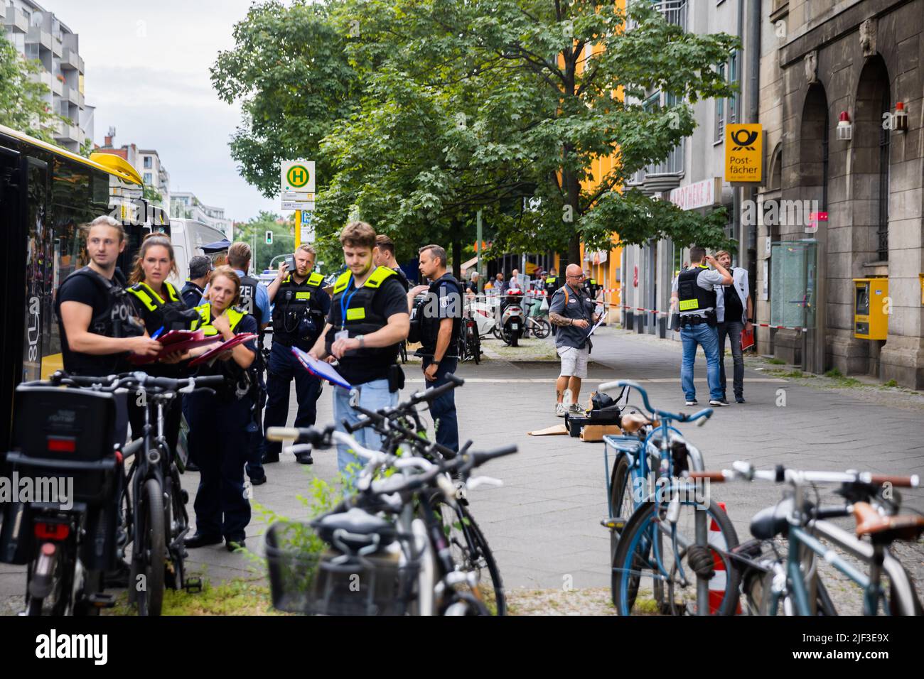 Berlin, Deutschland. 29.. Juni 2022. Während eines Polizeieinsatzes im Bezirk Wilmersdorf in der Uhlandstraße stehen Beamte auf einem Bürgersteig. Dort wurde ein gepanzertes Auto angegriffen. Vermutlich seien vier Personen verletzt worden, teilte ein Polizeisprecher der Deutschen Presse-Agentur mit. Die Täter sind auf der Flucht. Quelle: Christoph Soeder/dpa/Alamy Live News Stockfoto