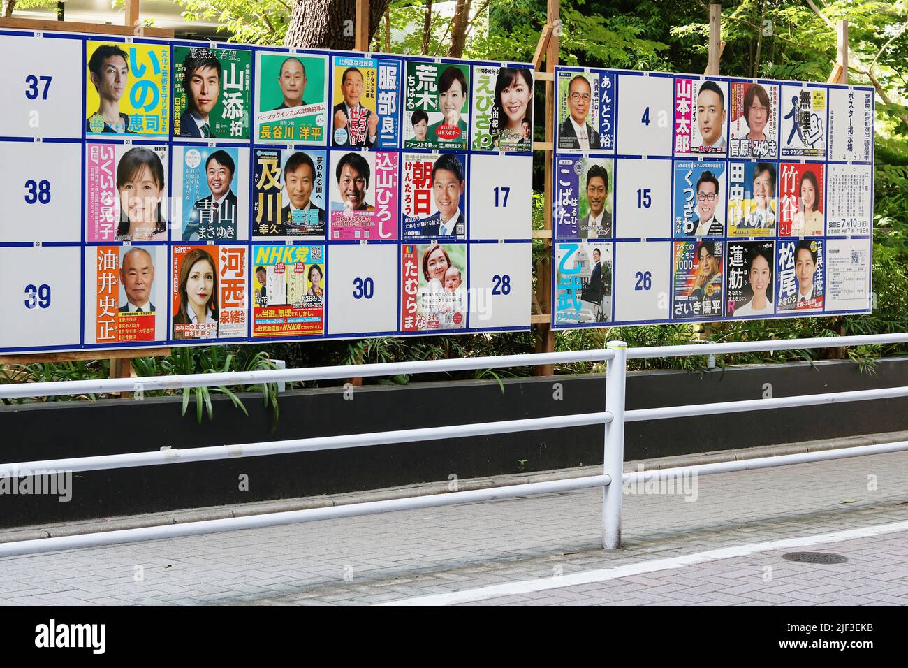 TOKIO, JAPAN – 28. Juni 2022: Eine offizielle Tafel auf einer Straße in Ginza mit Plakaten von Kandidaten bei den Wahlen zum Repräsentantenhaus. Stockfoto