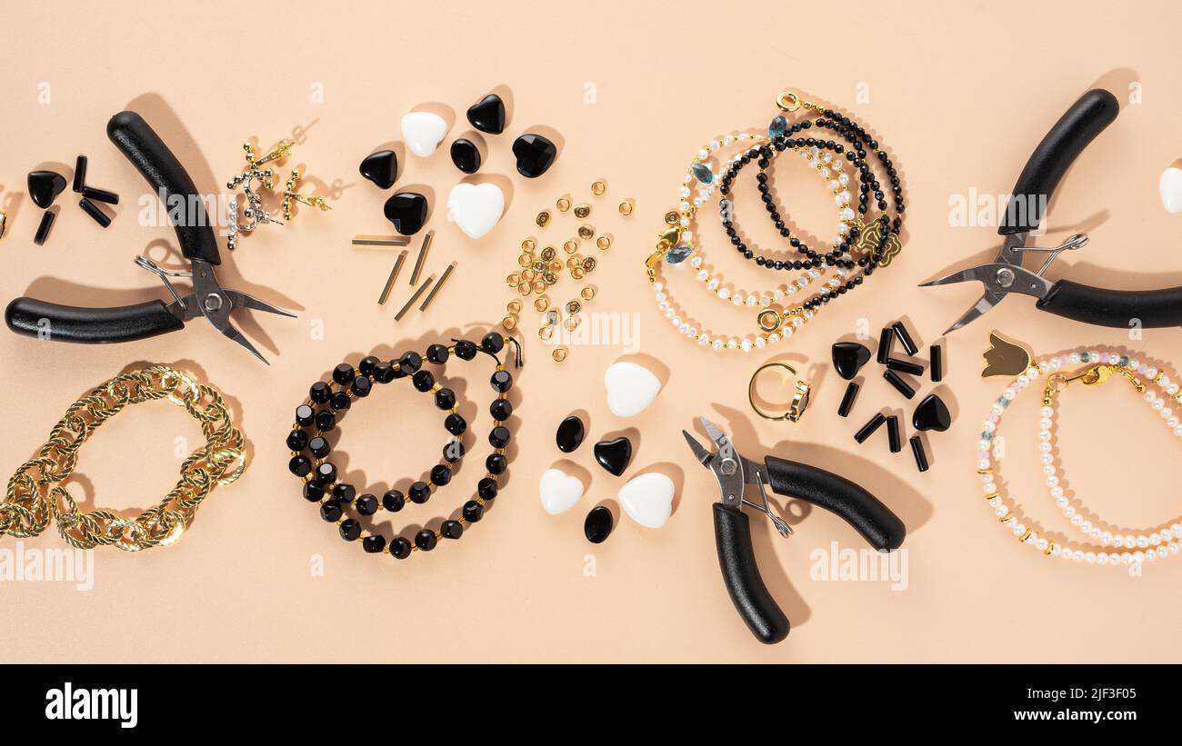 Werkzeuge und Zubehör für DIY-Schmuck am Arbeitsplatz. Flach lag auf beigem Hintergrund. Kreative flache Lay-Komposition, Banner, Draufsicht. Heimwerker-Hobby Stockfoto