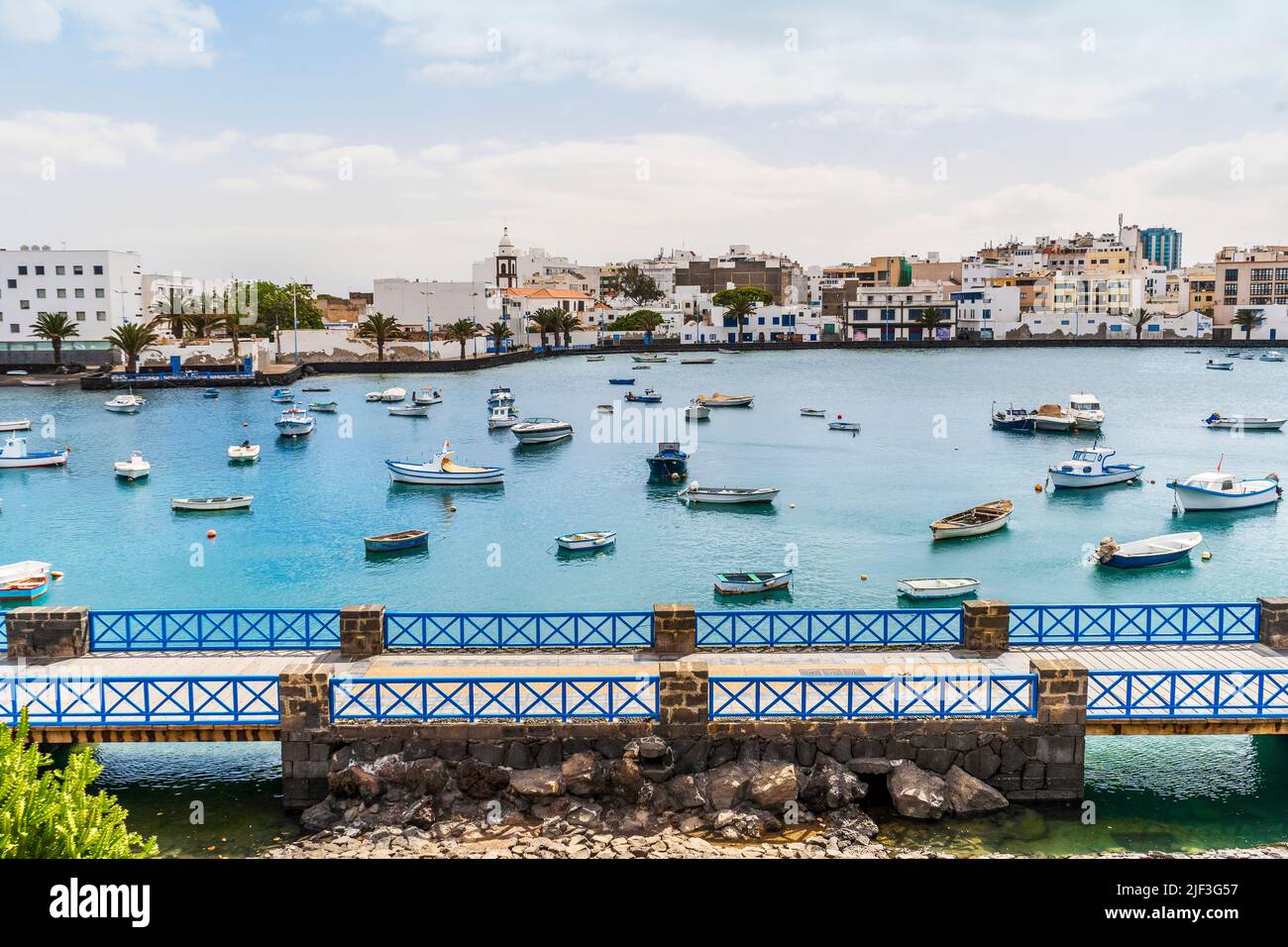 Schöner Kai mit historischer Architektur und Booten auf blauem Wasser in Arrecife, Lanzarote, Kanarische Inseln, Spanien Stockfoto