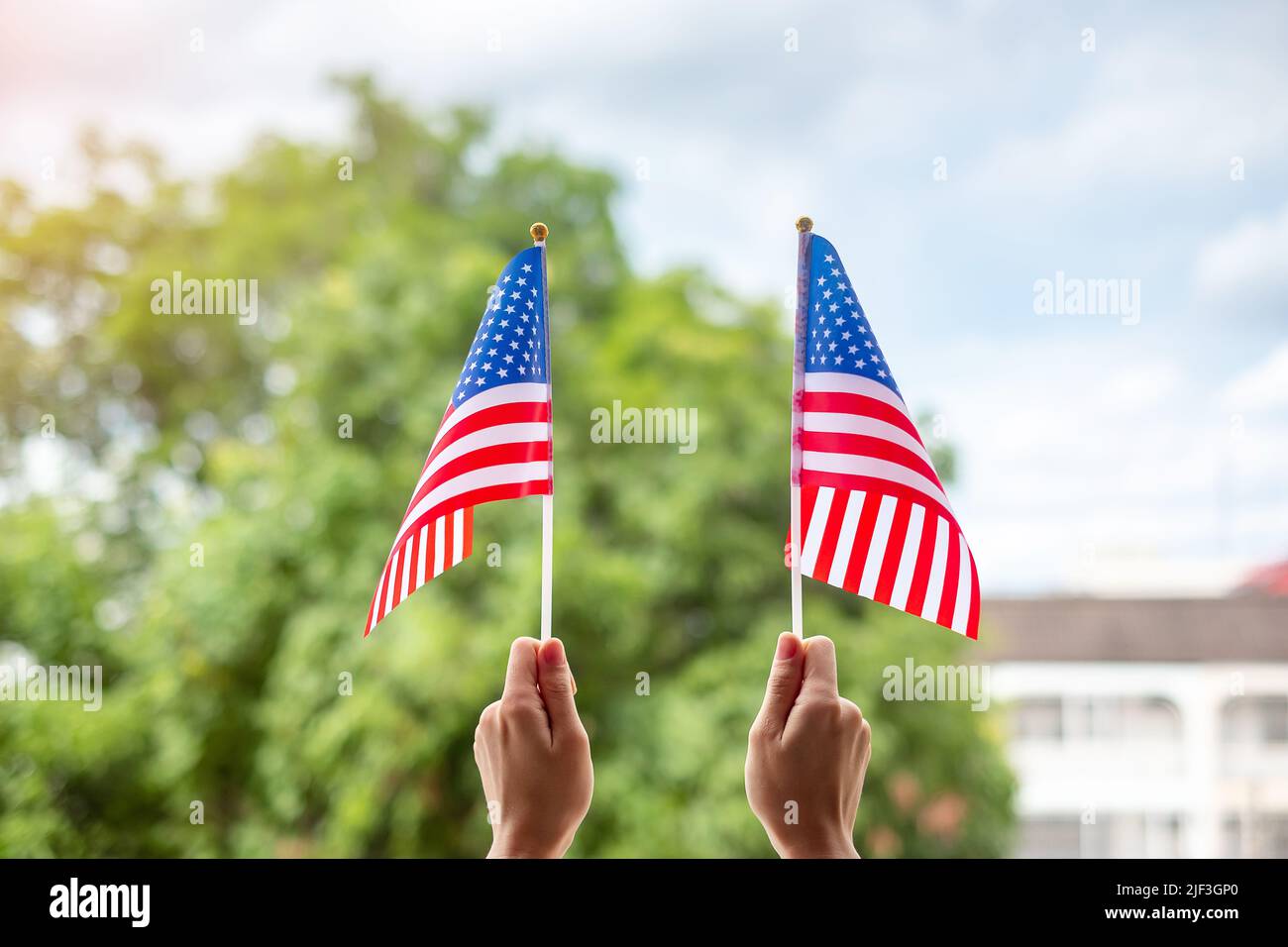 Hand hält die Flagge der Vereinigten Staaten von Amerika auf grünem Hintergrund. USA Feiertag der Veteranen, Memorial, Unabhängigkeit (4. Juli) und Labor Day concep Stockfoto