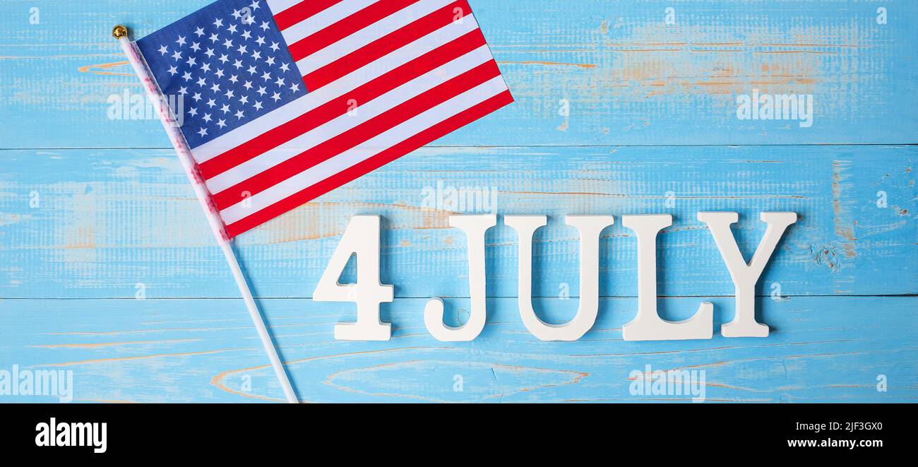 Text des 4. Juli und Flagge der Vereinigten Staaten von Amerika auf Holztisch Hintergrund. USA Unabhängigkeitsfeiertag und Festungskonzepte Stockfoto