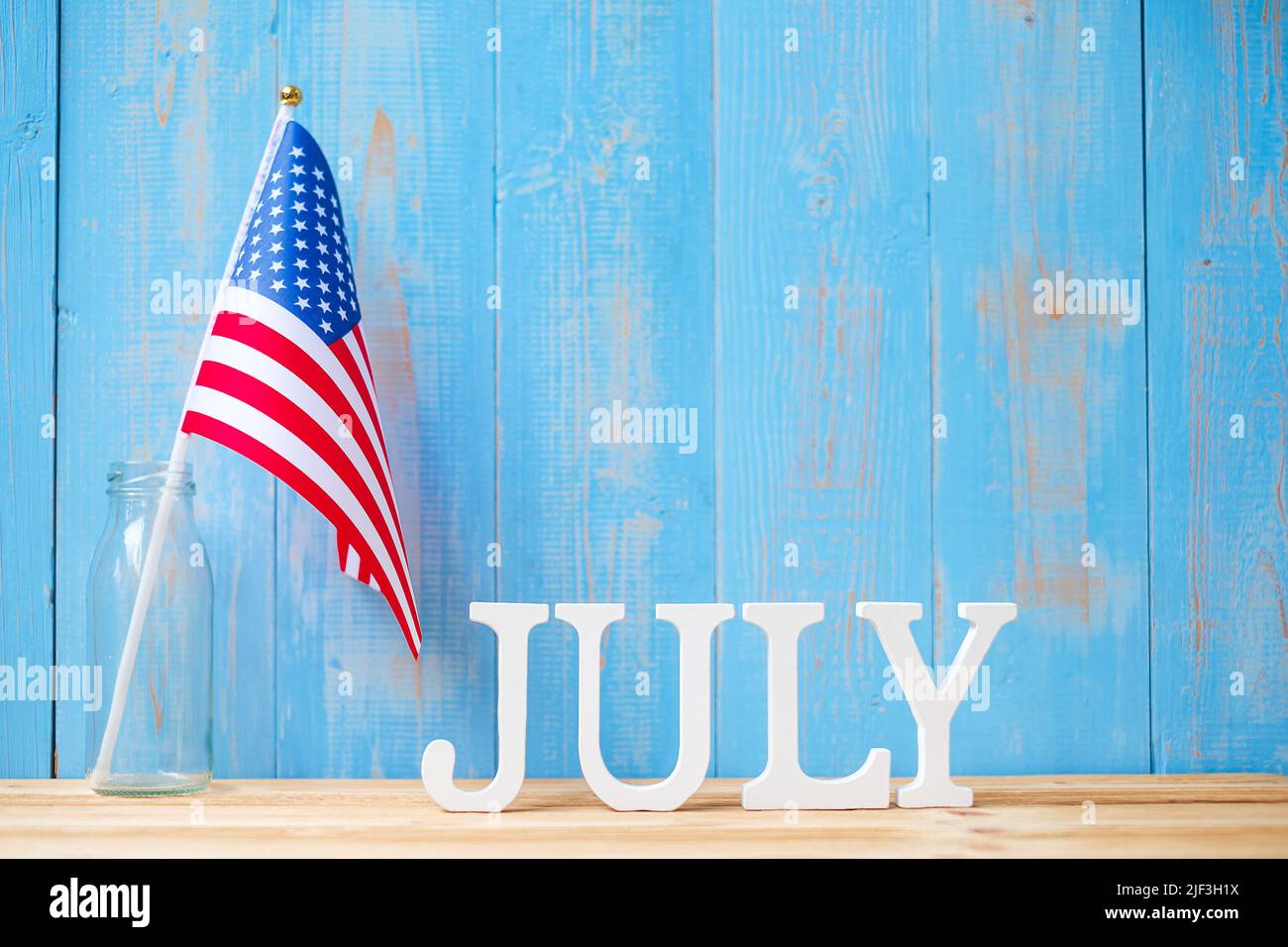 Juli Text und Flagge der Vereinigten Staaten von Amerika auf Holztisch Hintergrund. USA Unabhängigkeitsfeiertag und Festungskonzepte Stockfoto
