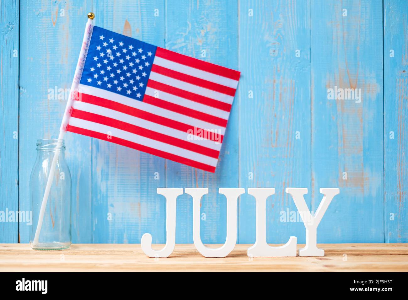 Juli Text und Flagge der Vereinigten Staaten von Amerika auf Holztisch Hintergrund. USA Unabhängigkeitsfeiertag und Festungskonzepte Stockfoto