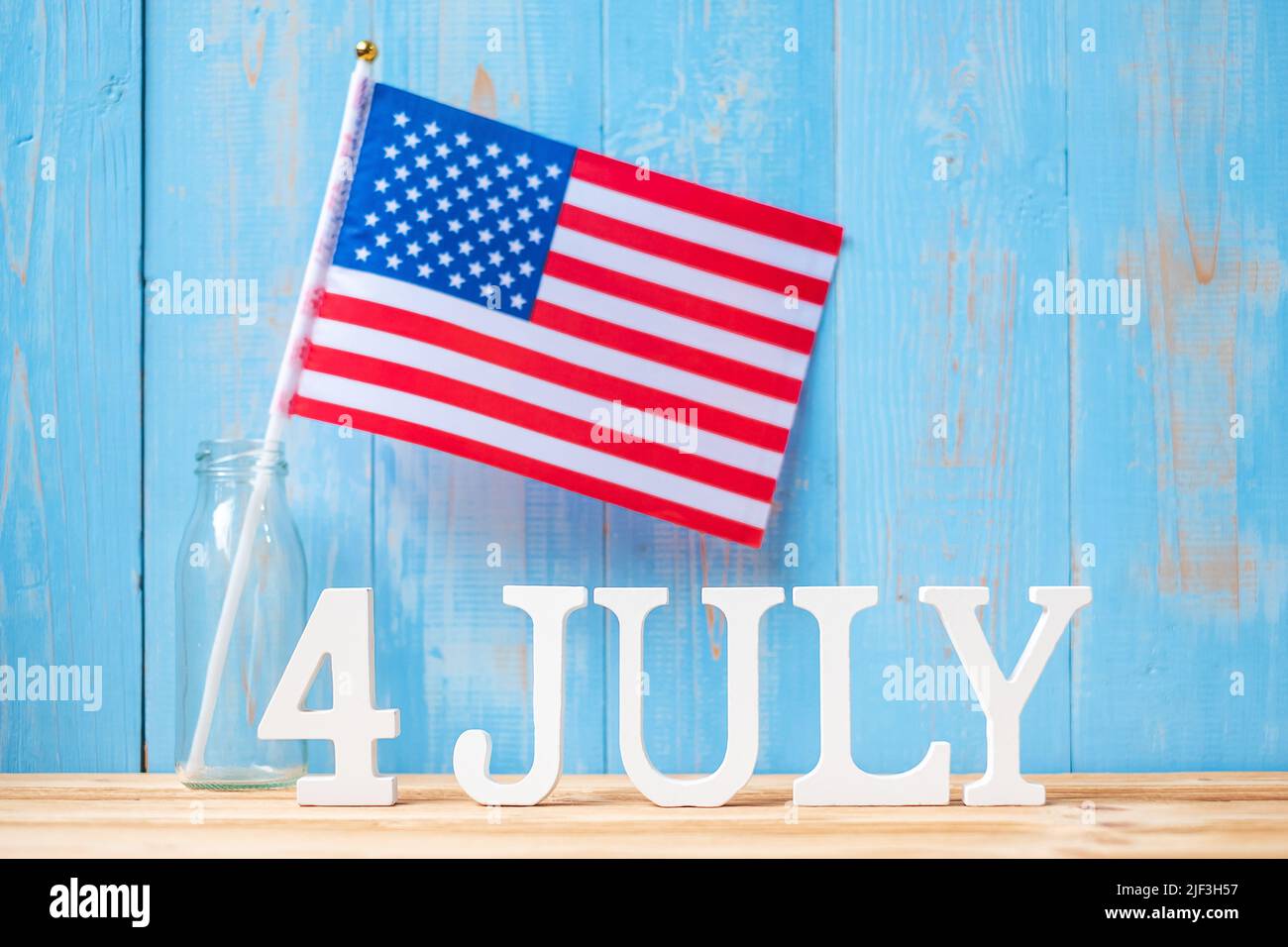 Text des 4. Juli und Flagge der Vereinigten Staaten von Amerika auf Holztisch Hintergrund. USA Unabhängigkeitsfeiertag und Festungskonzepte Stockfoto