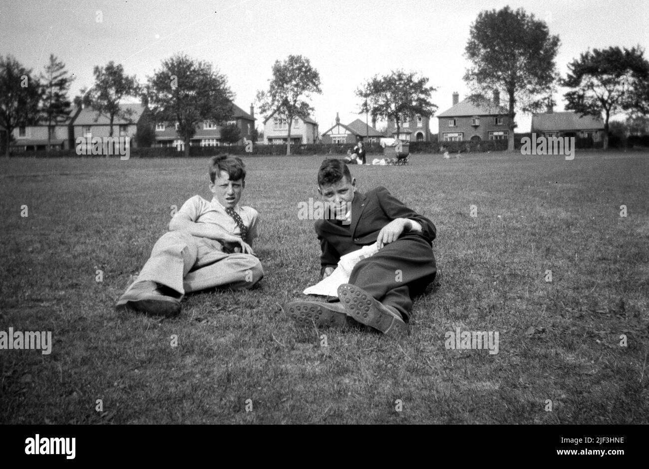 Ende 1930s, historisch, zwei Teenager, die sich auf dem Rasen in einem Park, Newbury, England, Großbritannien, entspannen. Stockfoto