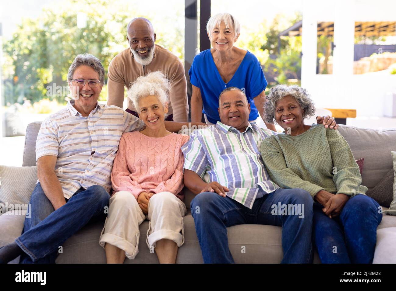 Portrait von glücklichen multirassischen männlichen und weiblichen älteren Freunden, die sich im Wohnzimmer im Pflegeheim entspannen Stockfoto
