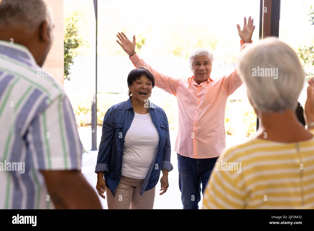 Biracial Senioren männlich und weiblich begrüßen fröhliche Freunde im Pflegeheim, kopieren Raum Stockfoto