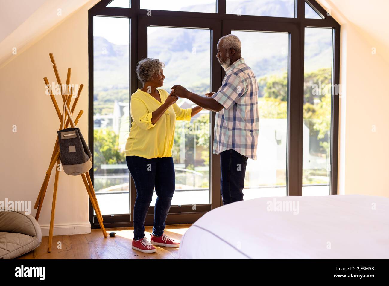 afroamerikanische Senioren tanzen im Pflegeheim am Fenster Salsa Stockfoto