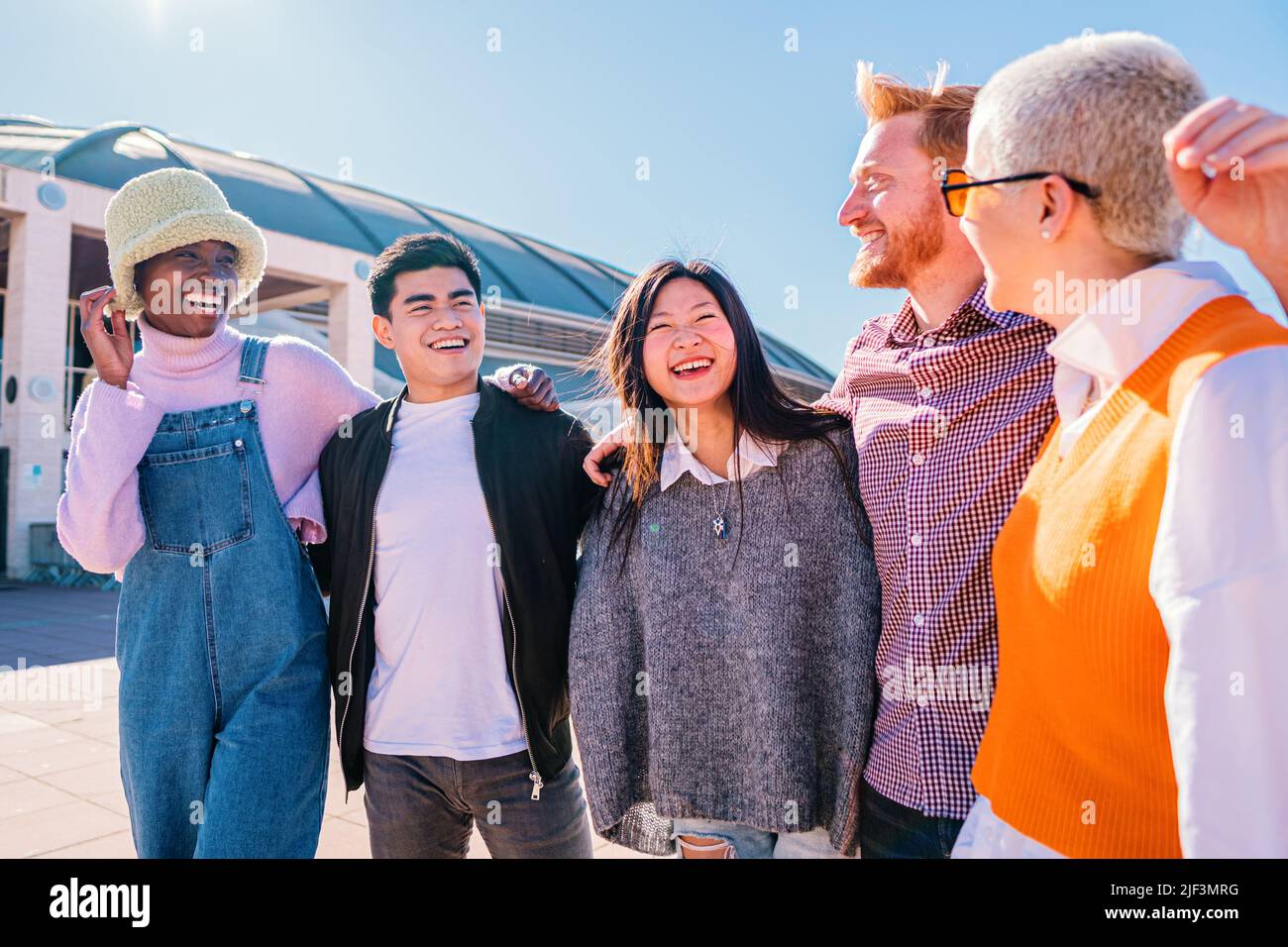 Fröhliche Teenager-Freunde in Schattierungen, die auf der Straße reden. Junge multiethnische Freunde sprechen und verbringen Zeit miteinander. Stockfoto