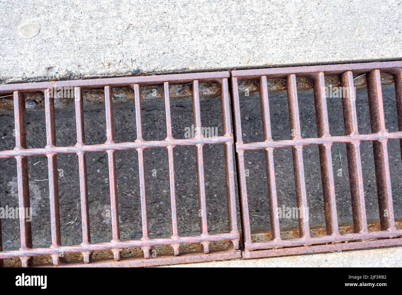 Rost über einem Regenwassergruben in einer Betonplatte. Stockfoto