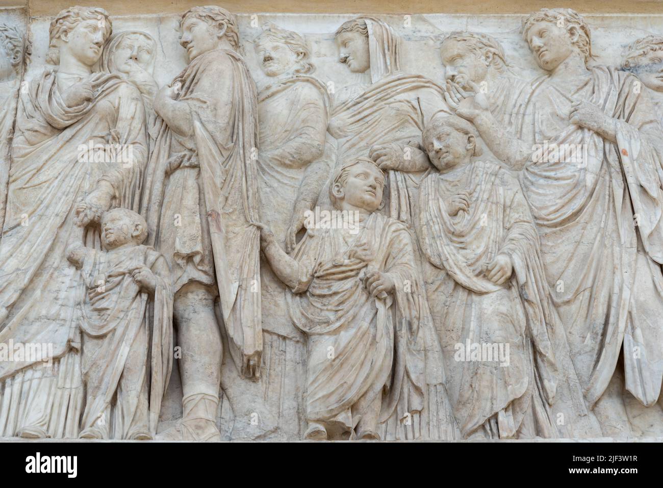 Antike römische Illustrationen, die eine Gruppe von Erwachsenen und Kindern in einer Marmorwand darstellen Stockfoto