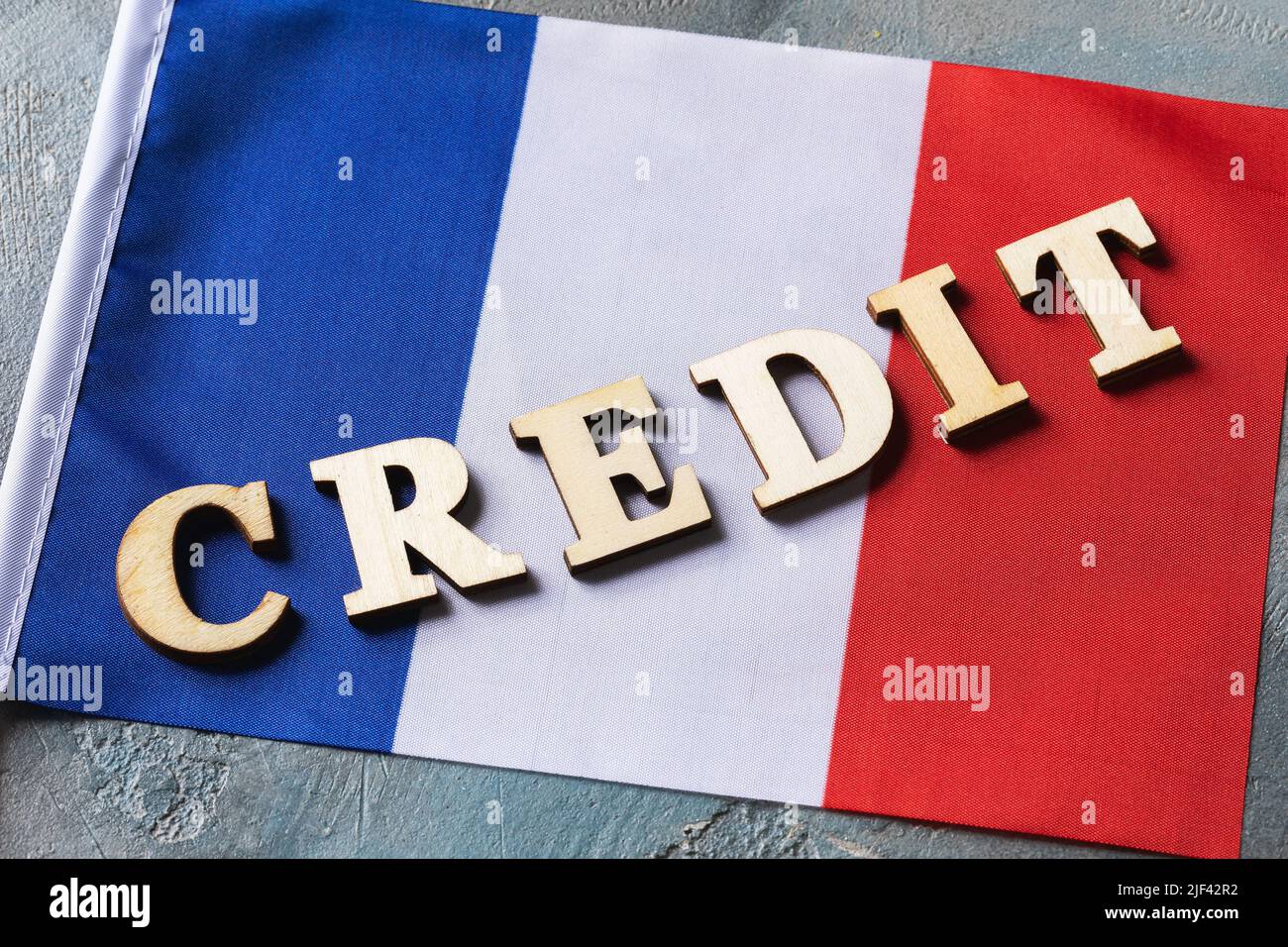 Holzbuchstaben Text und französische Flagge auf abstraktem Hintergrund, Leihkonzept aus Frankreich Stockfoto
